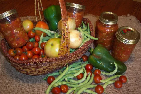 Basket of vegetables and jars or homemade salsa.
